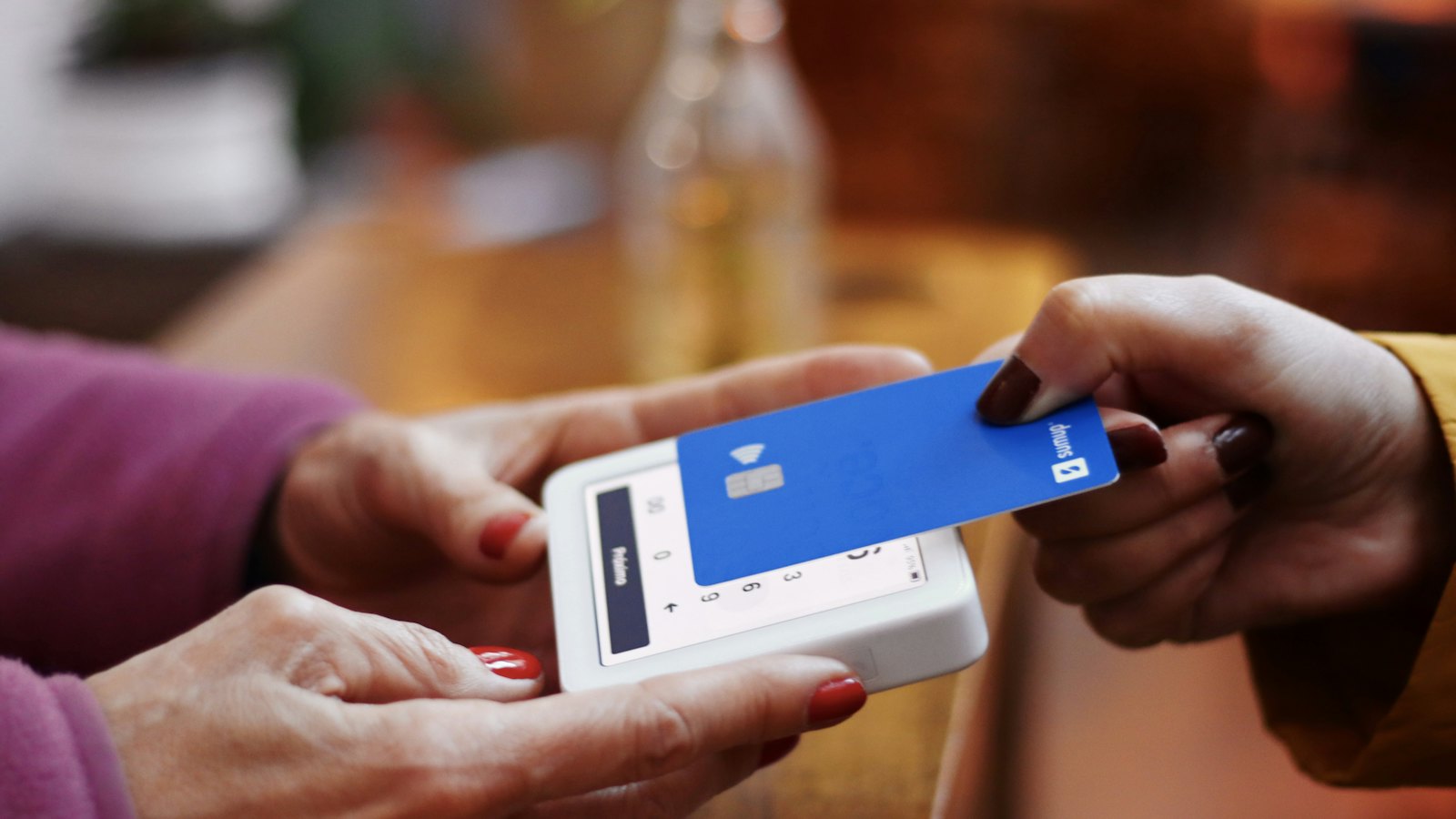 A card being tapped on a small payment reader