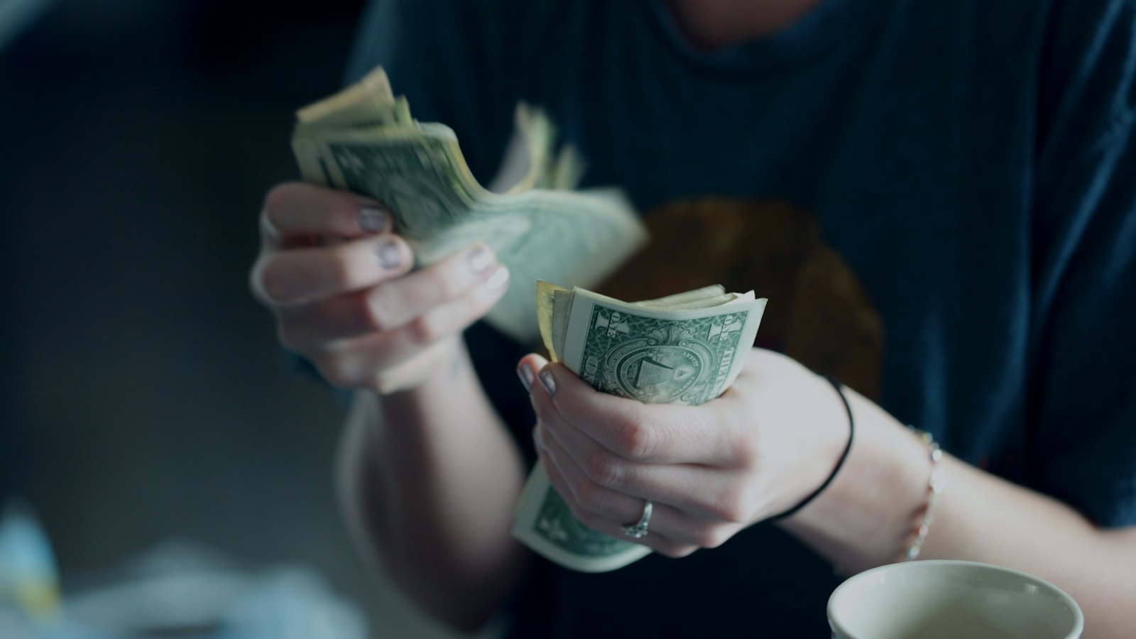 A person counting a handful of banknotes