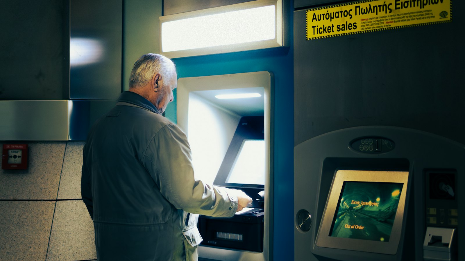 An older man using a cash machine