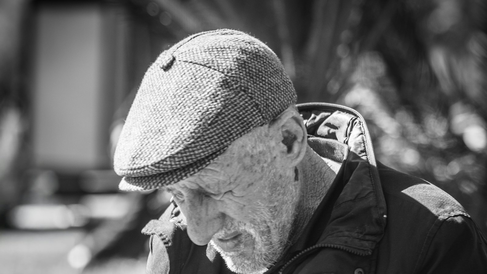 A man looking down at his phone, worried