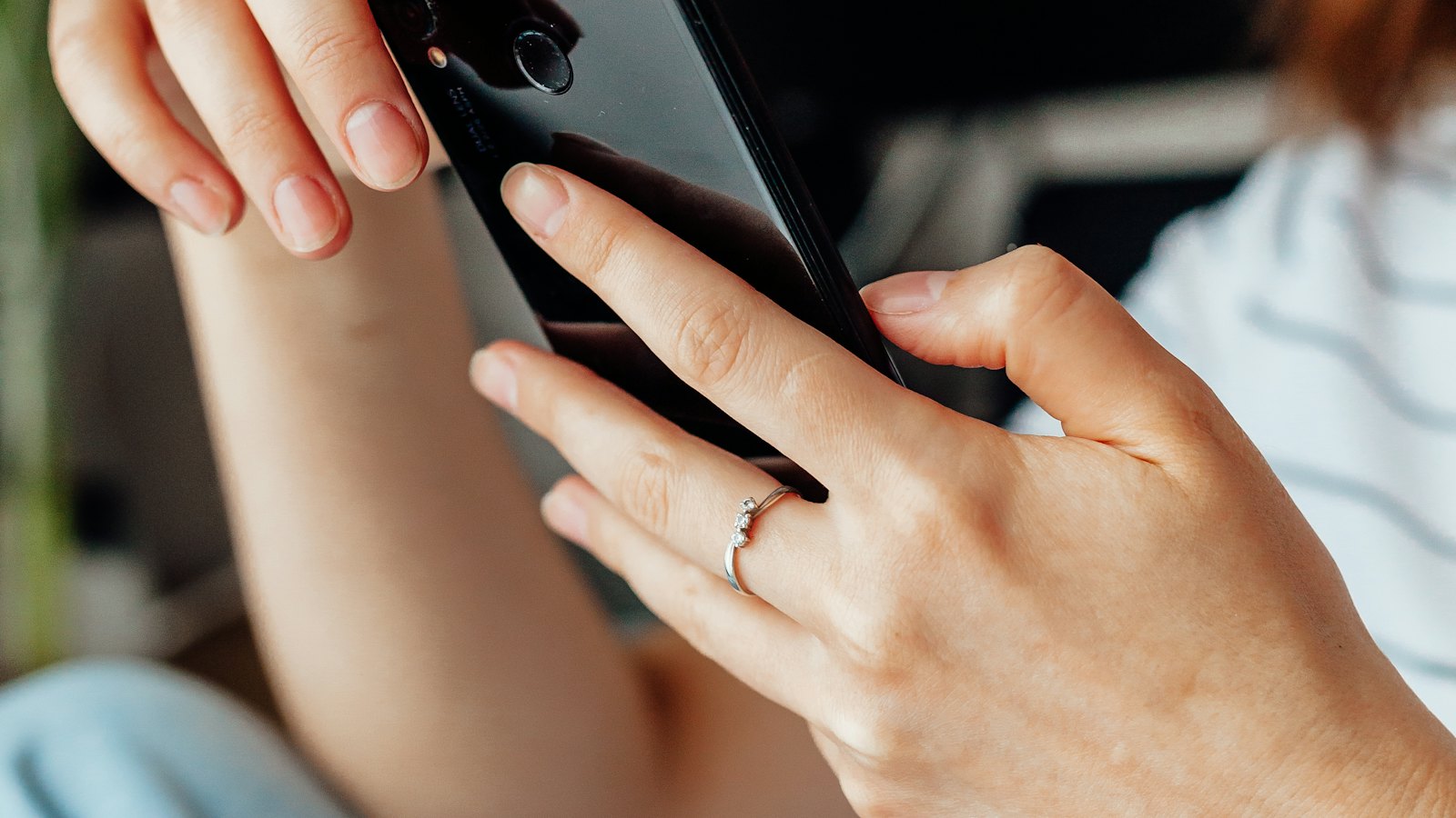 Close-up of hands holding a phone and scrolling