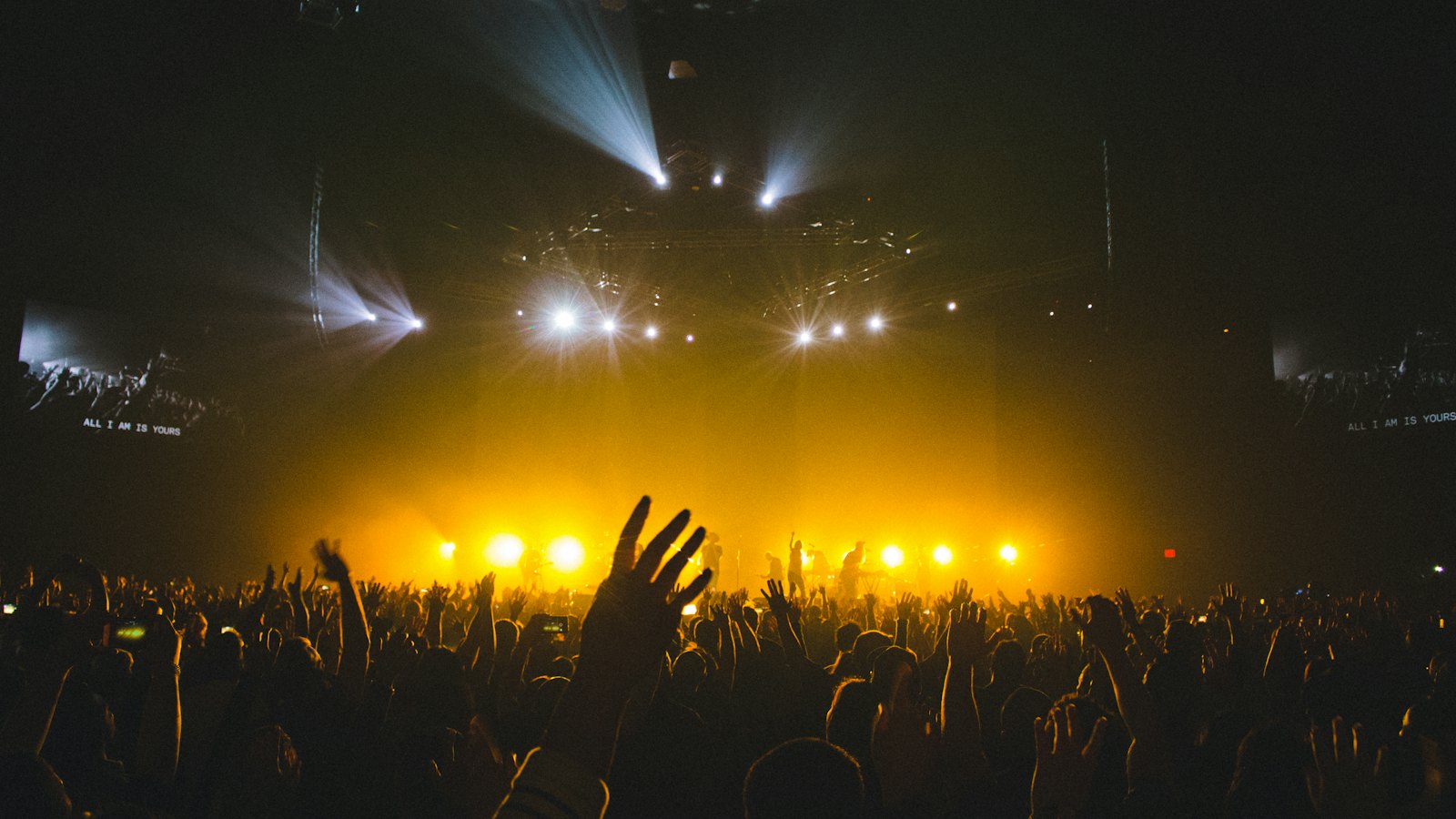 A concert crowd in front of a brightly lit stage