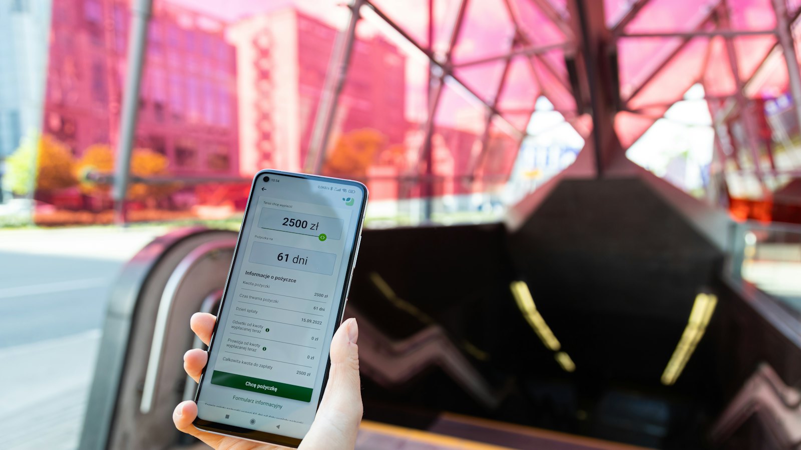 A hand holding a phone showing an account balance