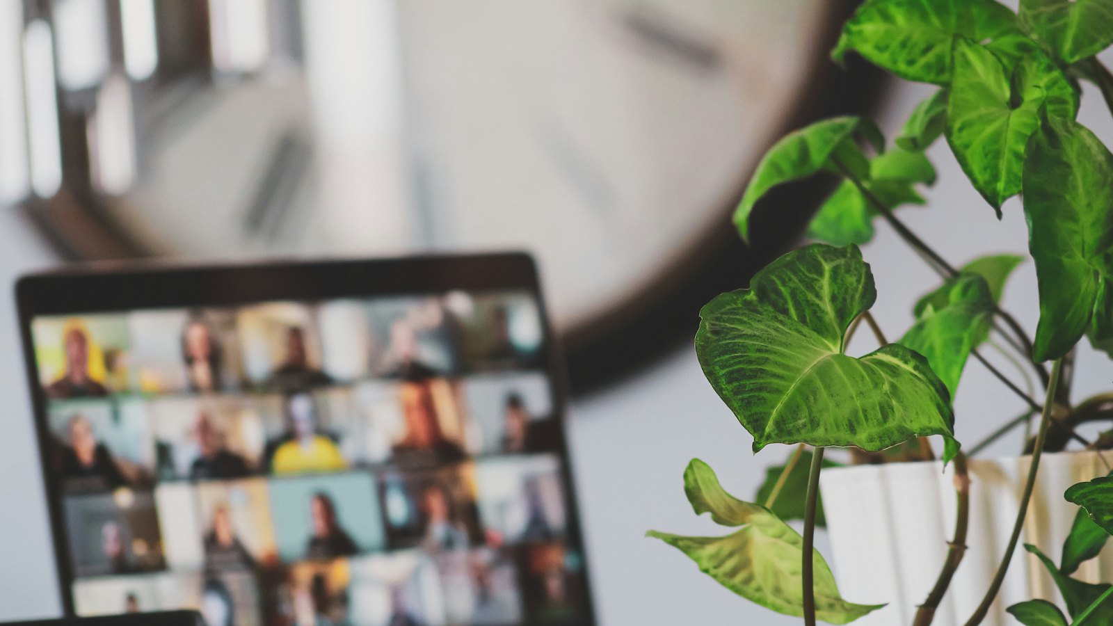 A laptop showing a video call with many participants