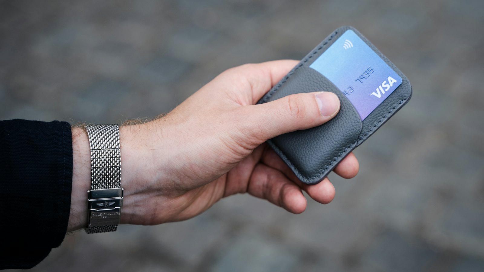 A hand holding a card wallet