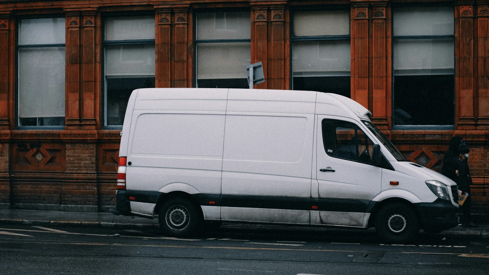 A white delivery van parked on a city street
