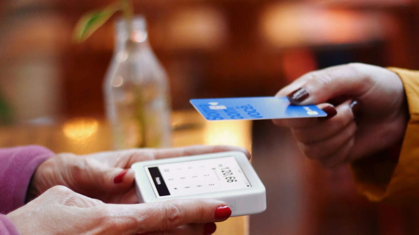 A customer paying by card on a handheld reader