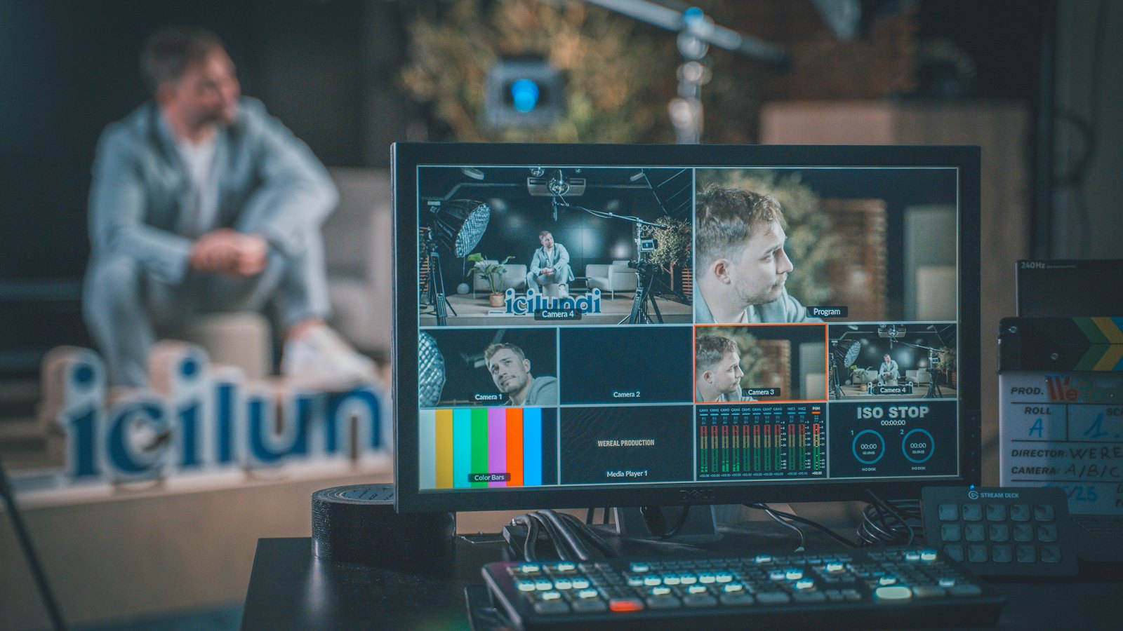 A video production desk with a monitor showing several camera feeds