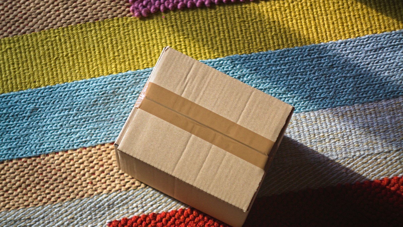 A cardboard parcel on a striped rug