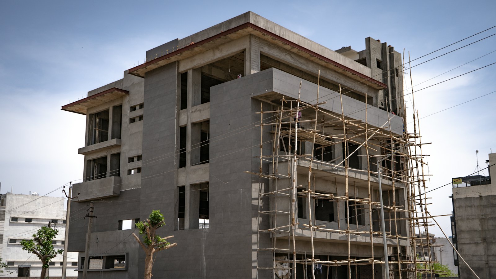 A multi-storey concrete building under construction with scaffolding