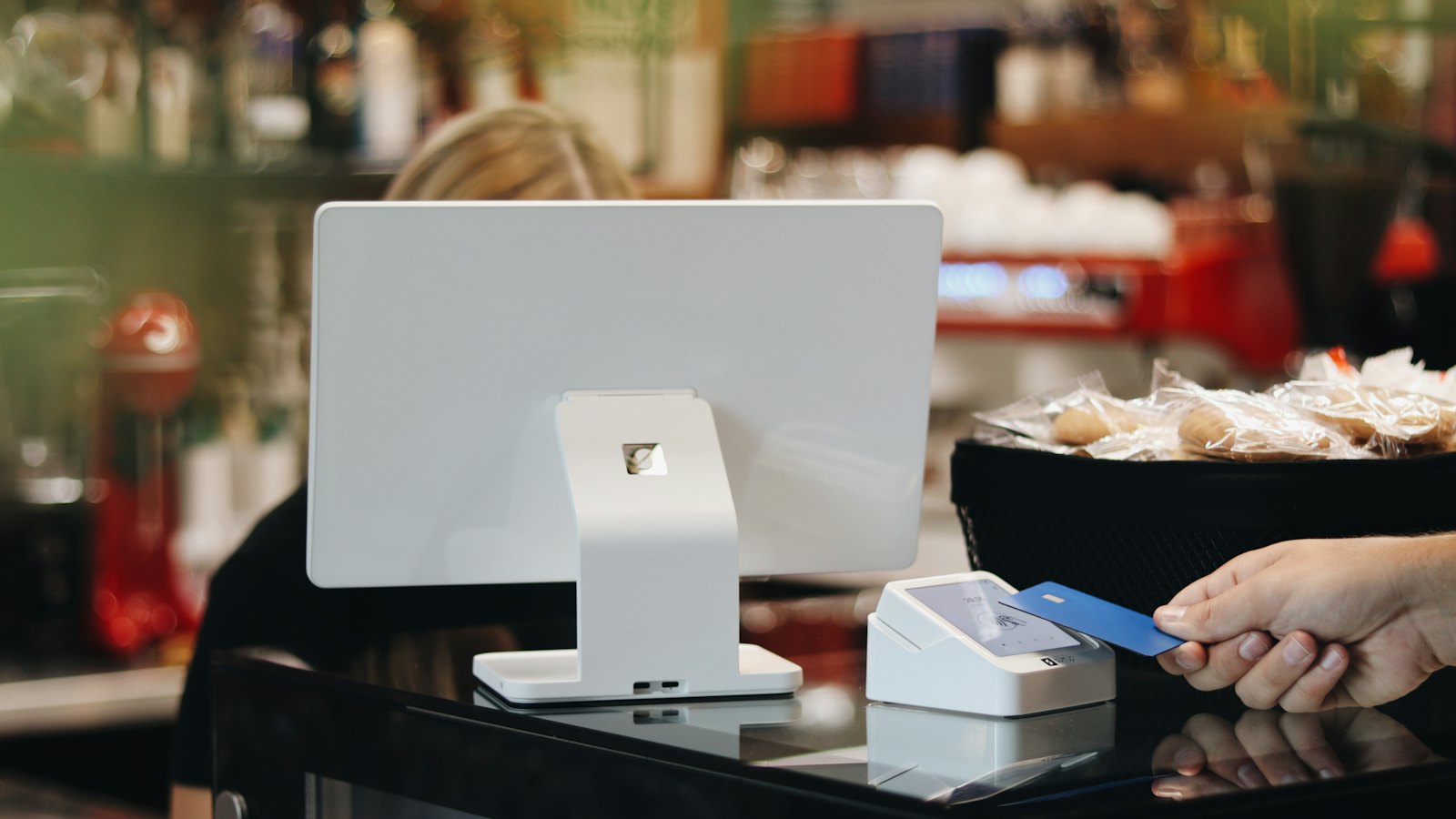 A customer tapping a card on a cafe terminal