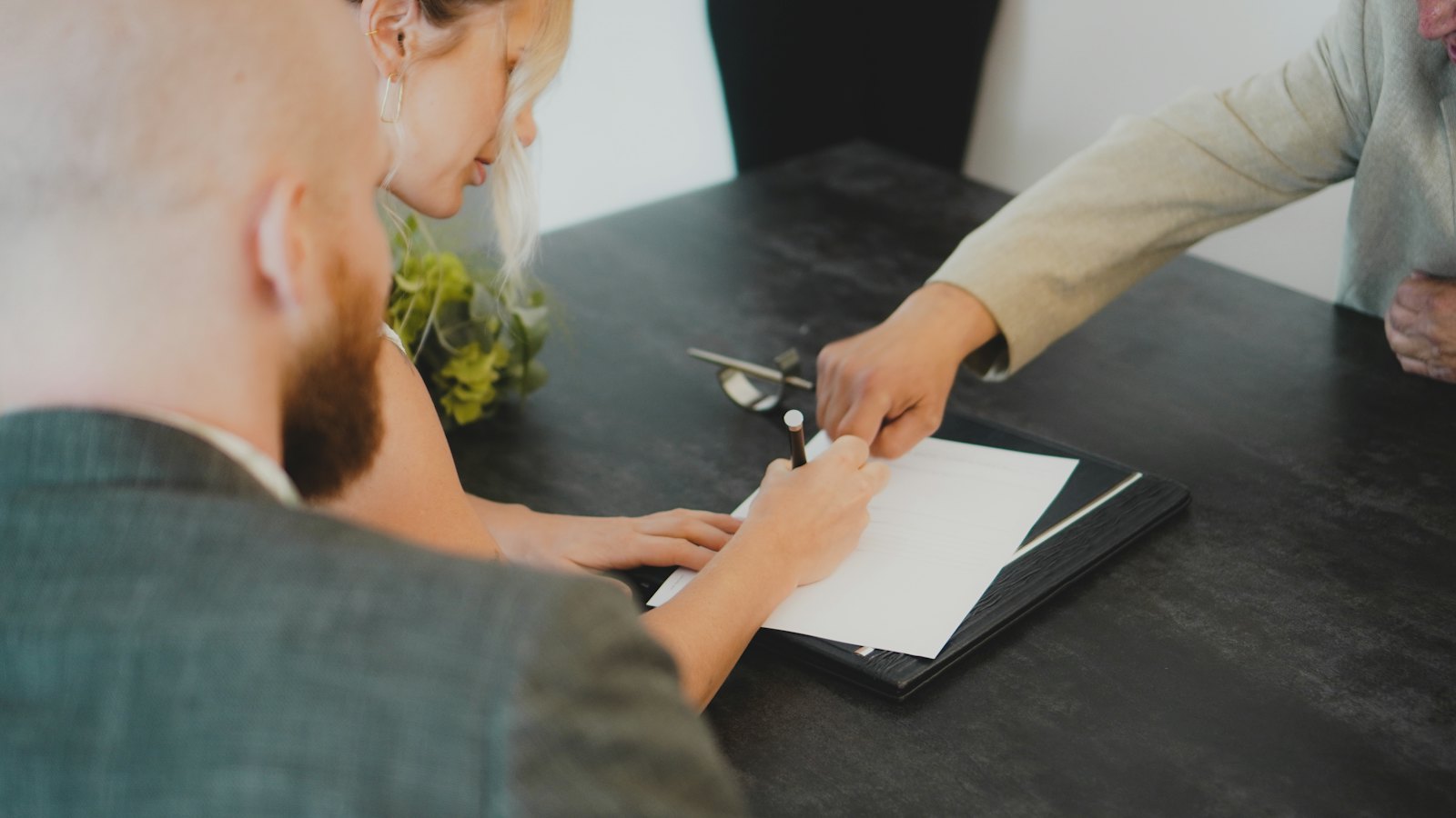Two people signing a document at a desk