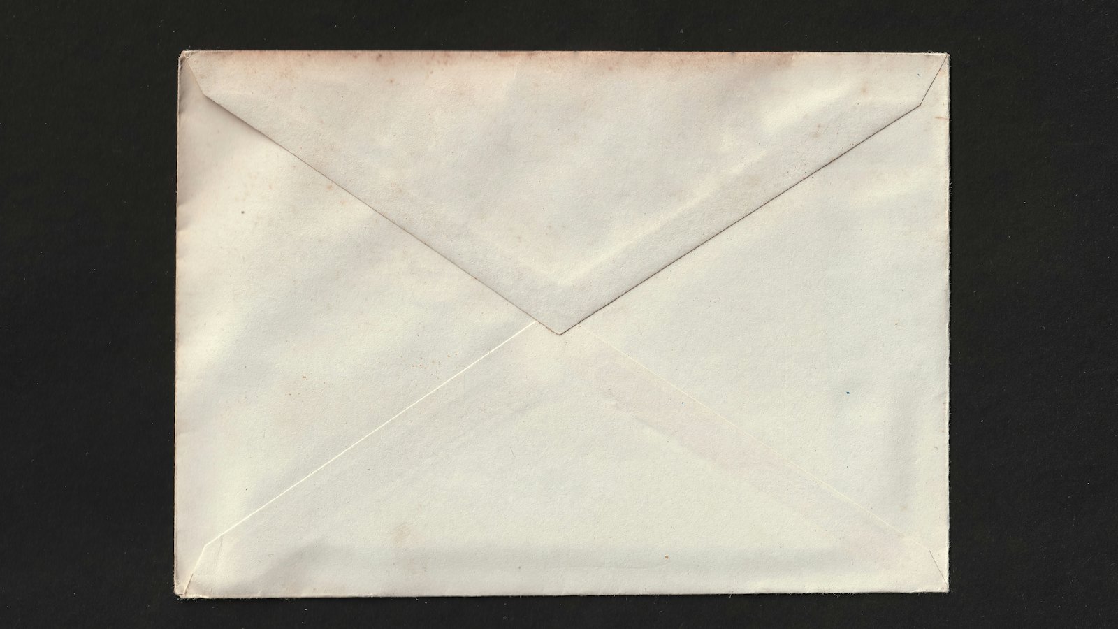 A sealed white envelope on a dark background