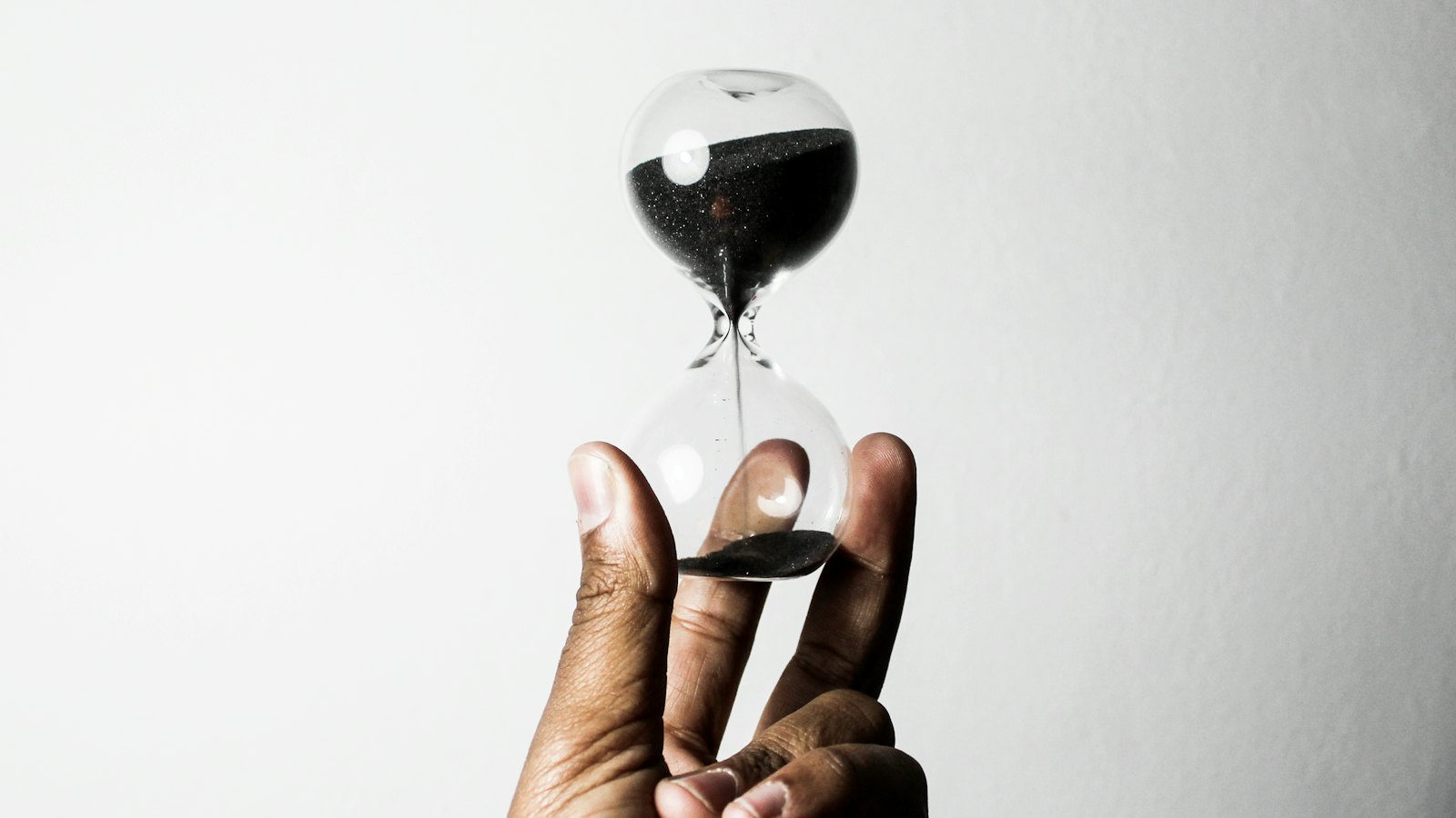 A hand holding an hourglass