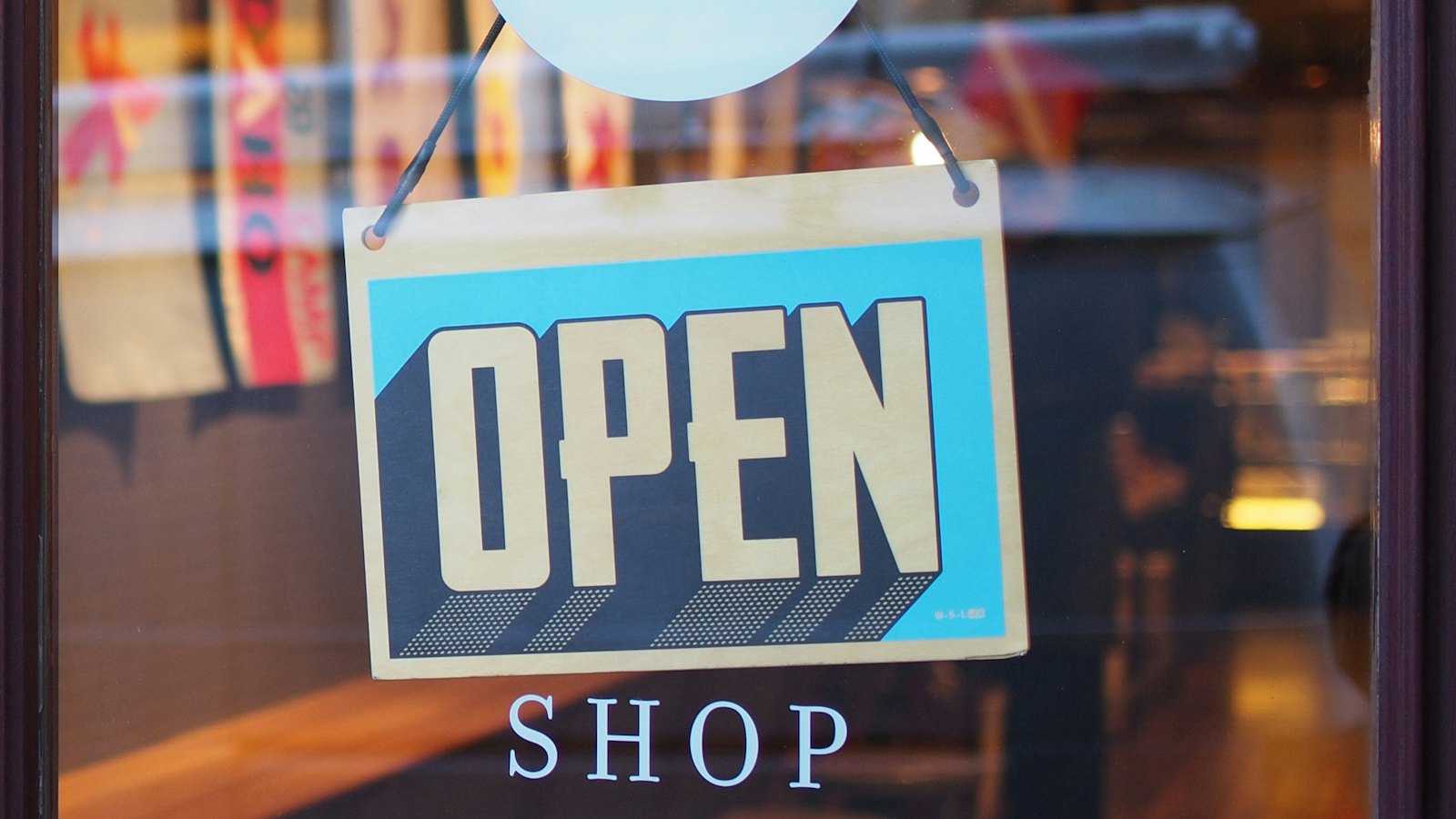 An open sign hanging in a shop window