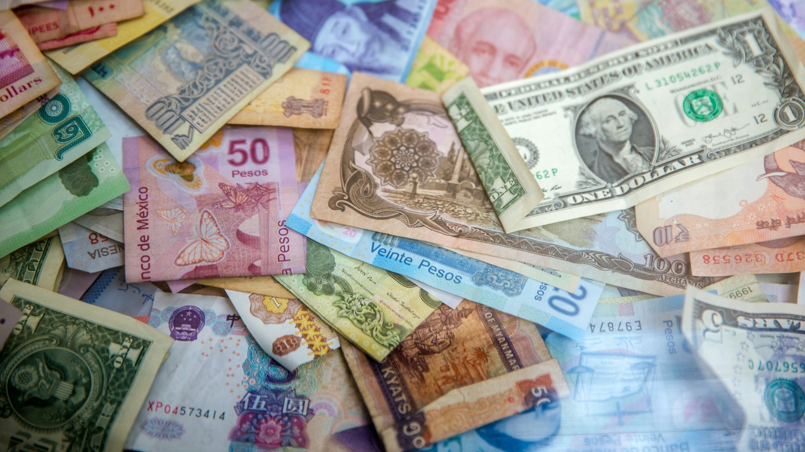 Banknotes from many countries scattered on a table