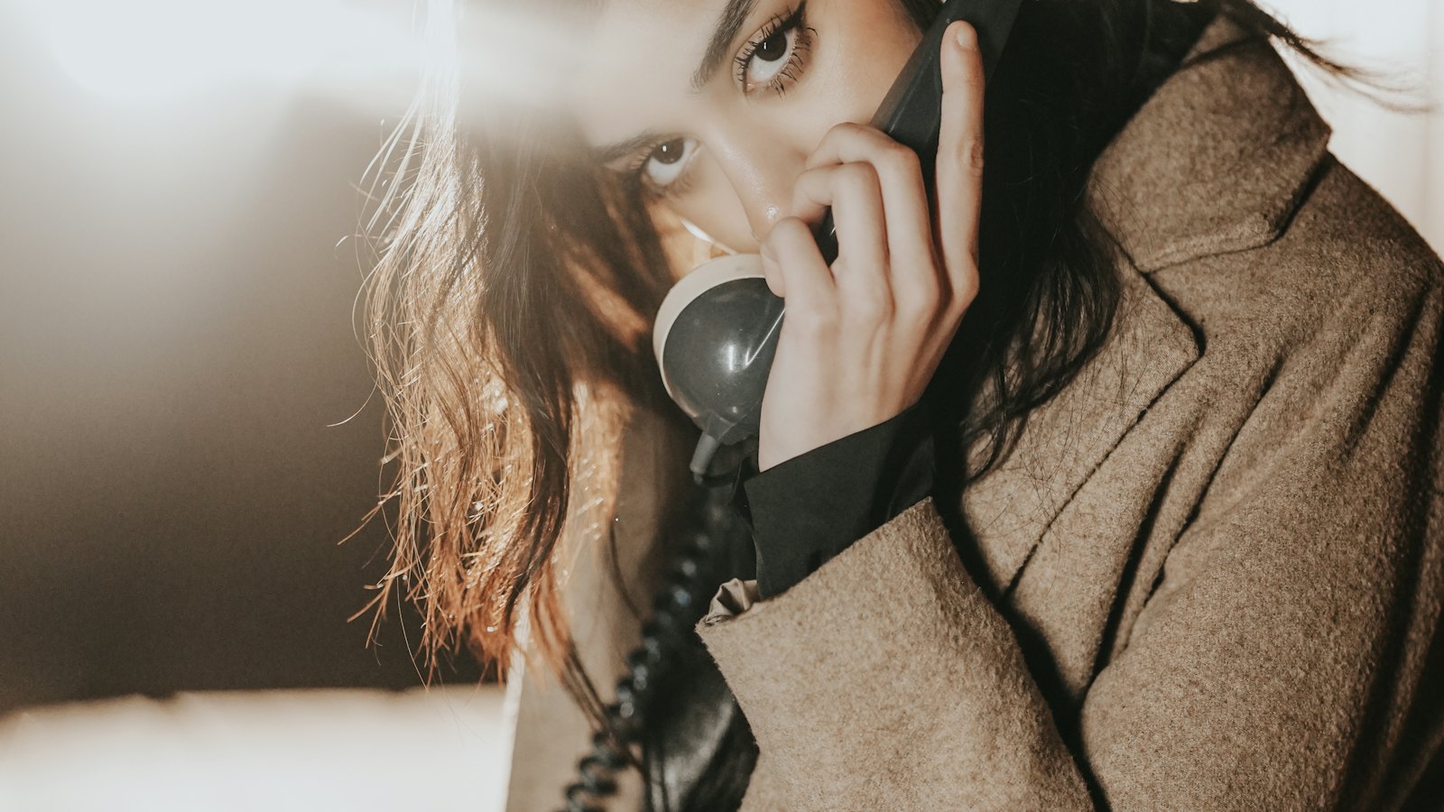 A worried woman holding a telephone receiver to her ear