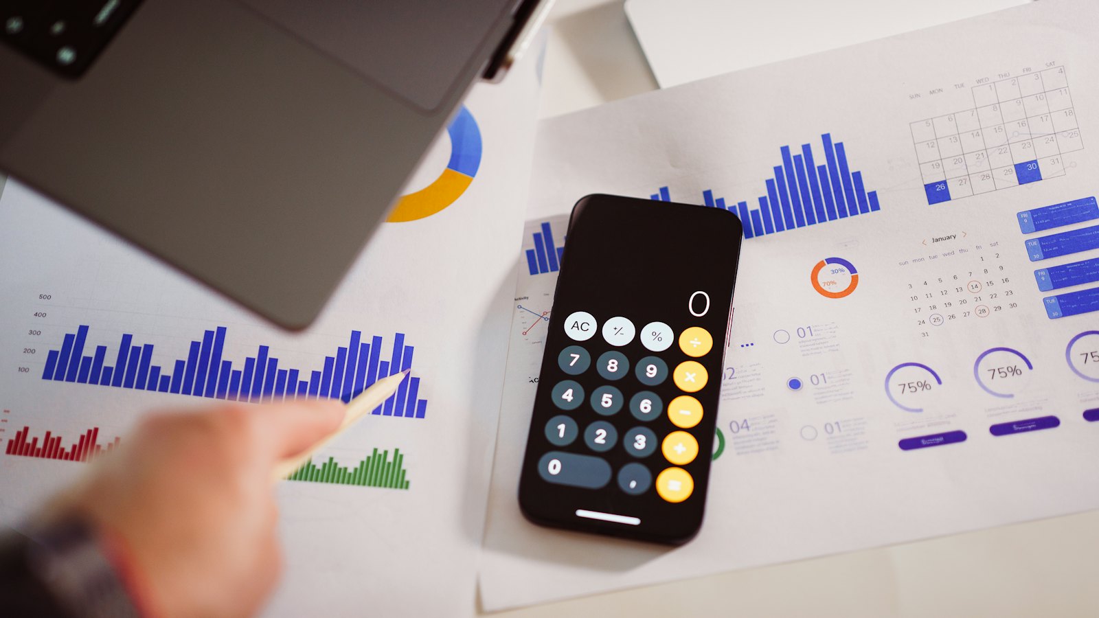 A calculator and printed charts on a desk