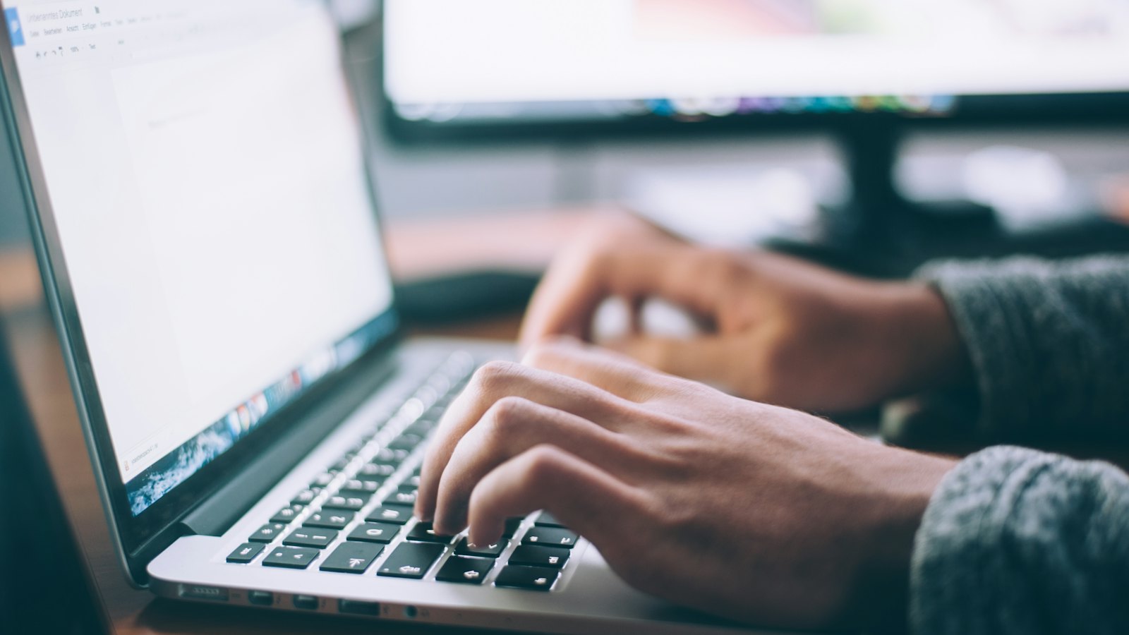 Close-up of hands typing on a laptop keyboard