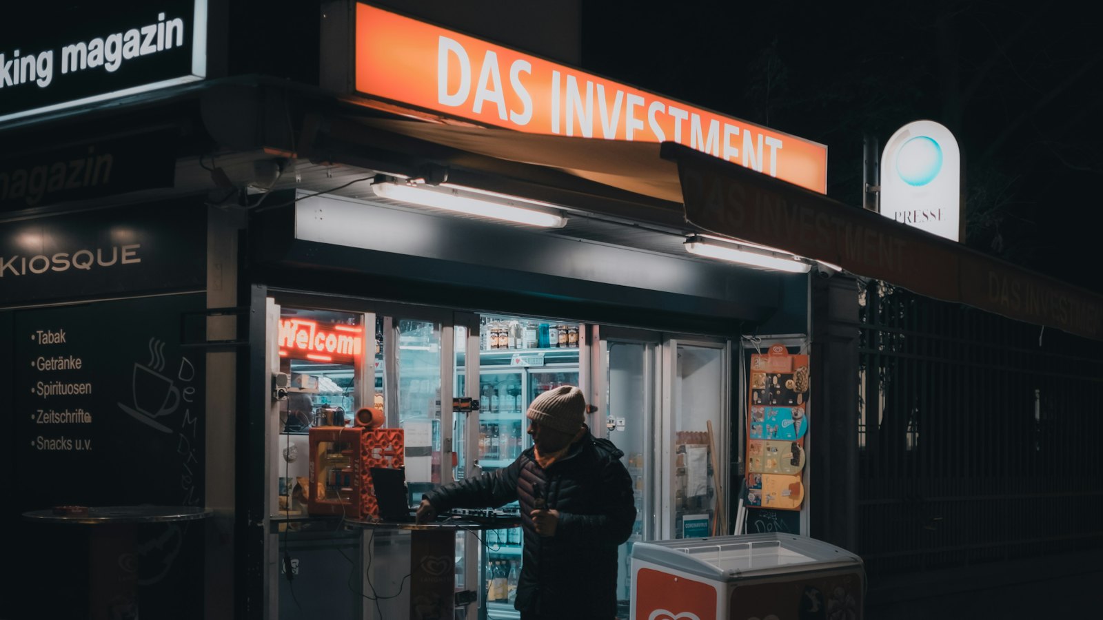 A street kiosk lit up at night