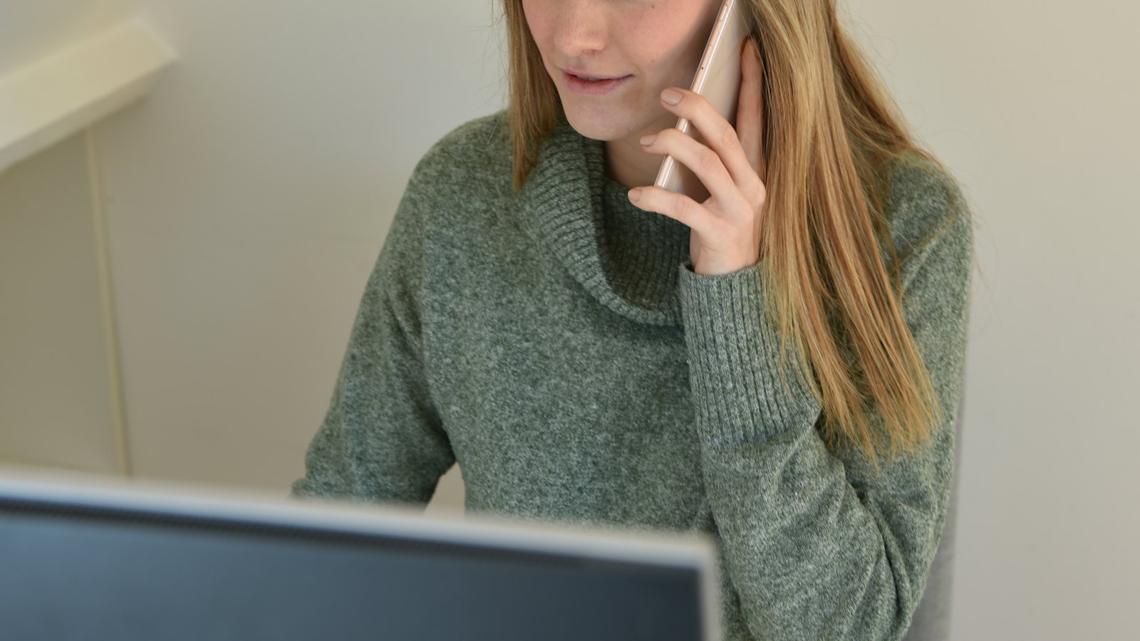 A woman on a phone call at her desk