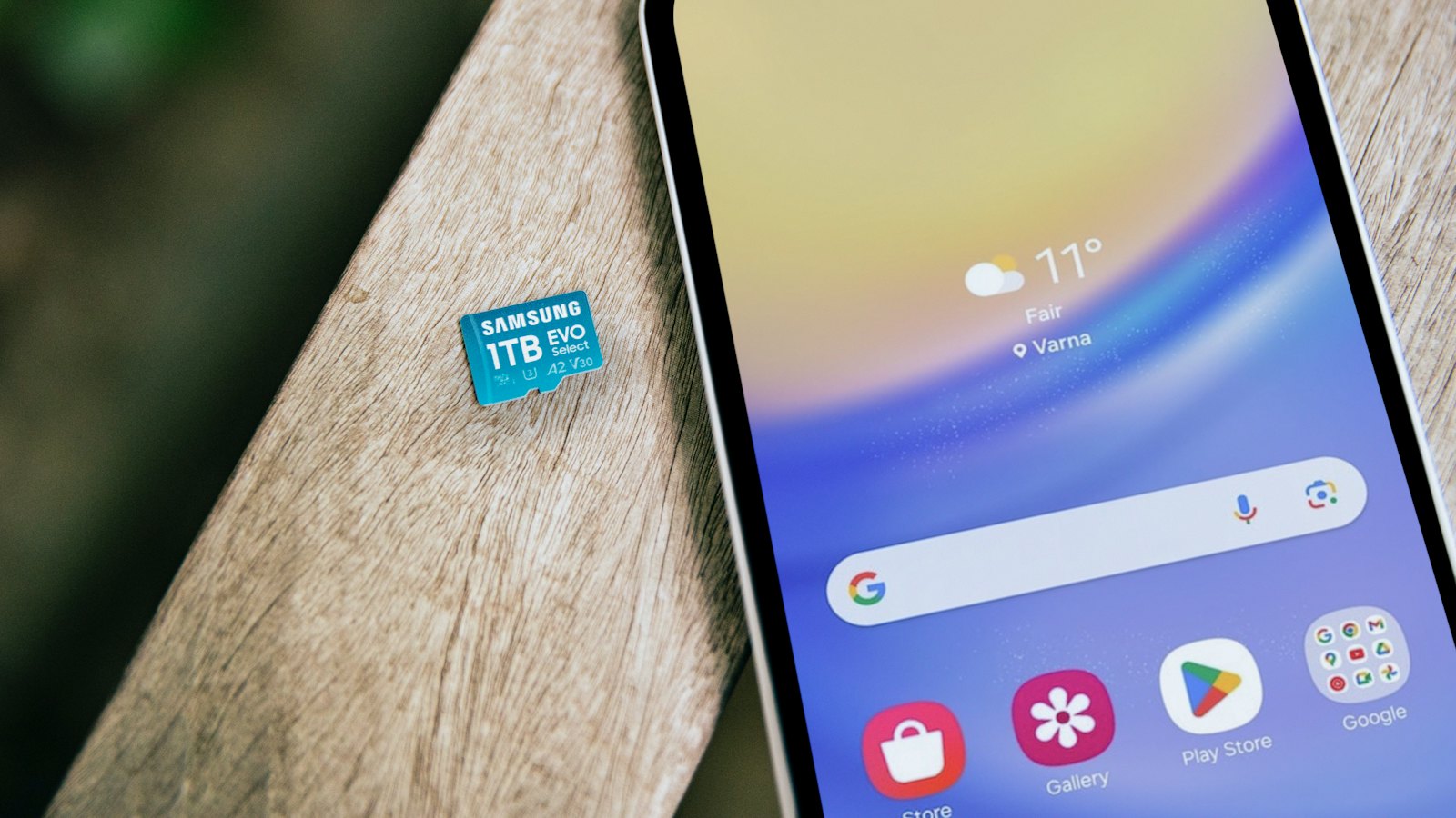 A phone lying on a wooden surface beside a memory card