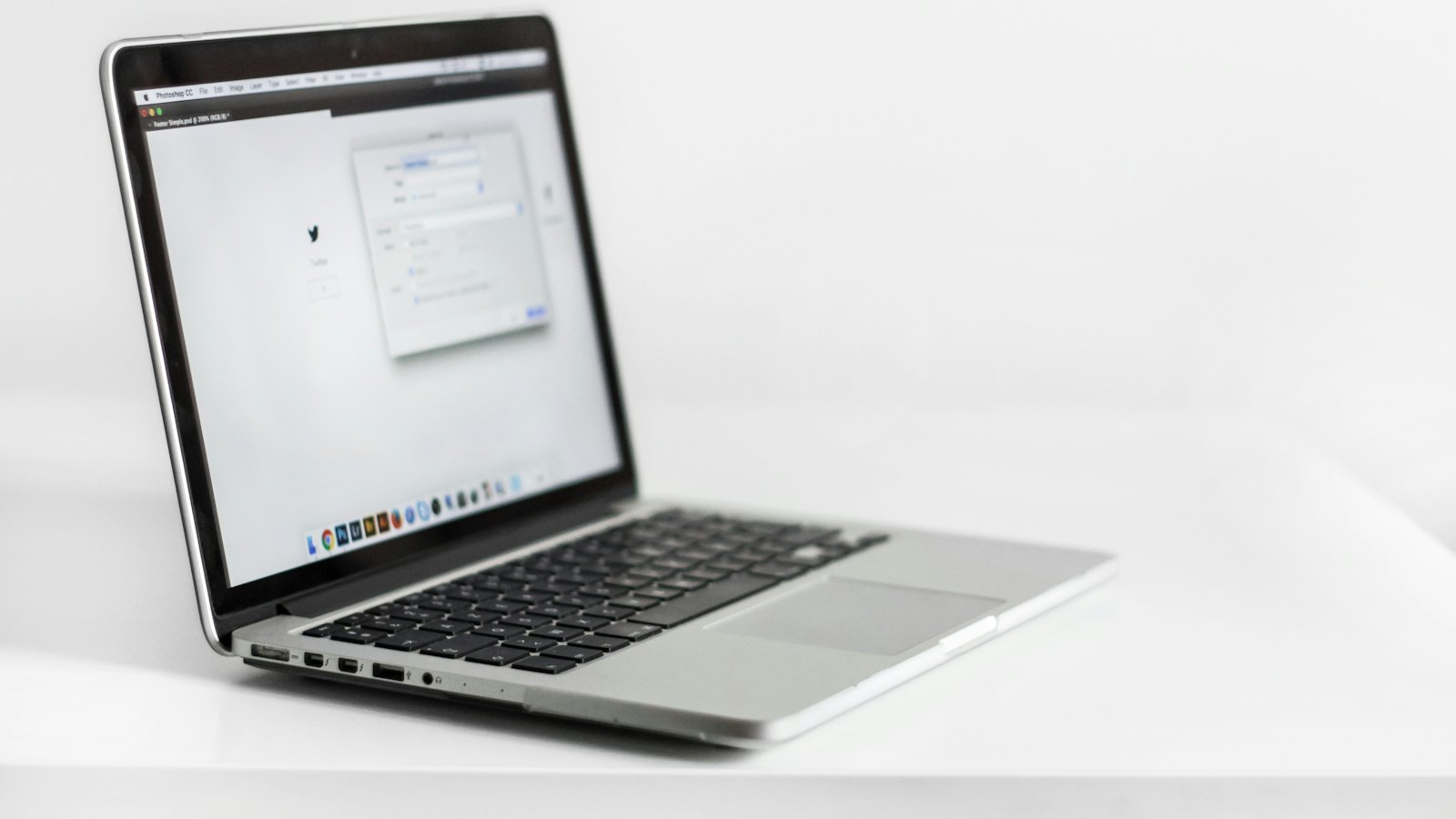 A silver laptop open on a white table
