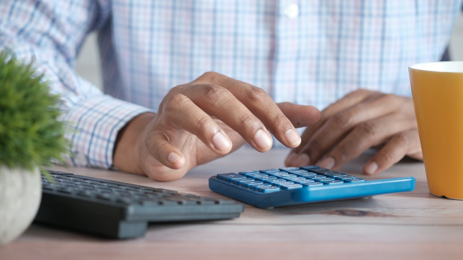 A person using a calculator at a desk