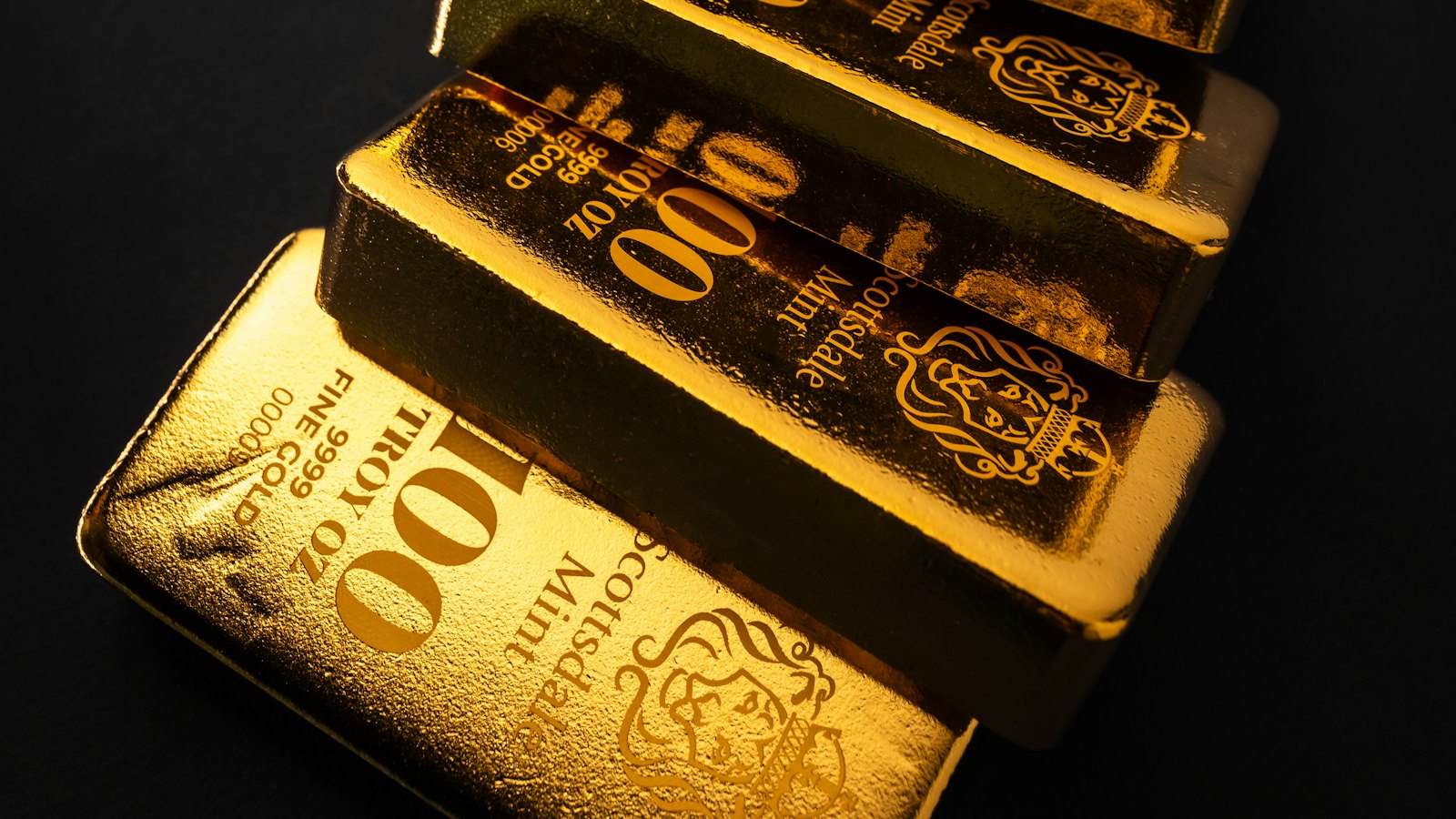 Gold bars stacked on a dark surface
