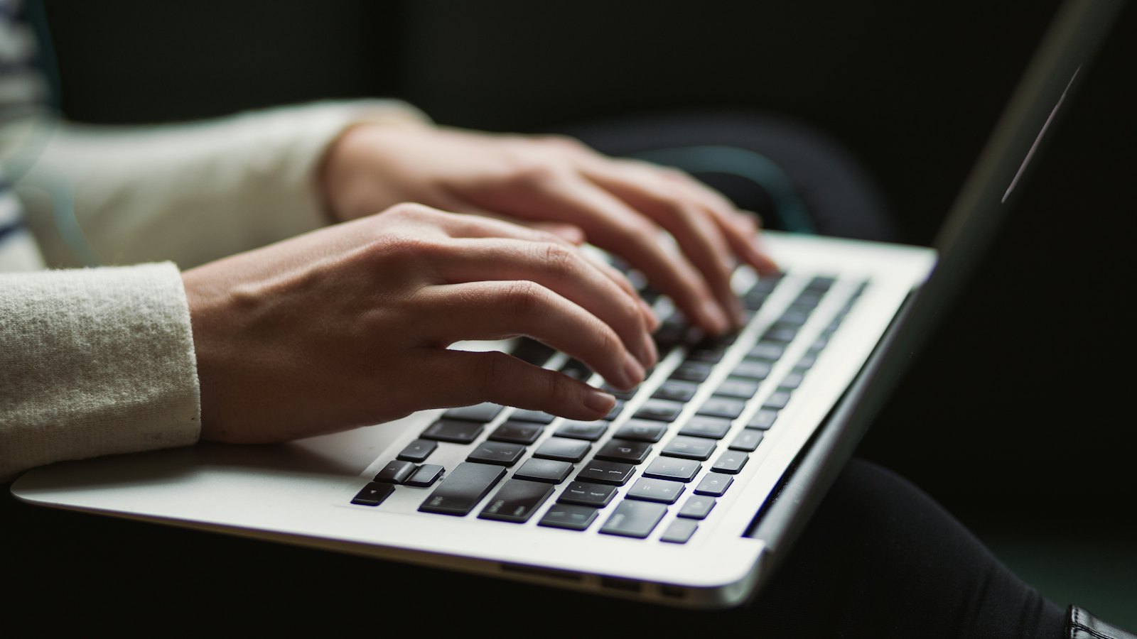 Hands typing on a laptop keyboard