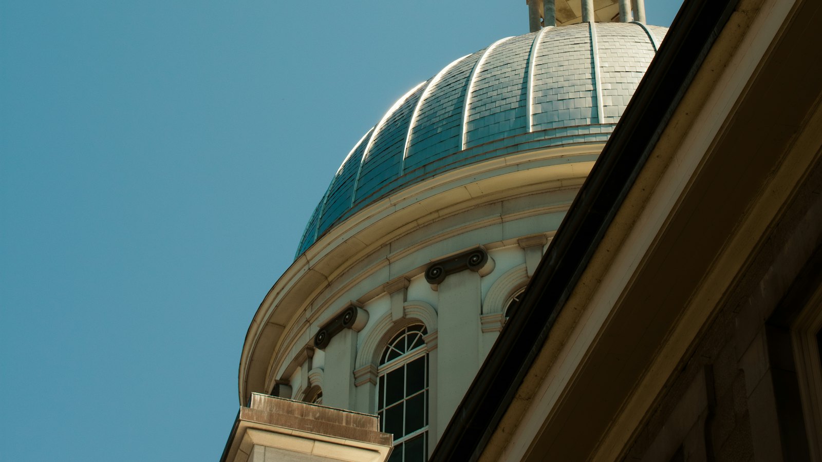 The green dome of a government building against a blue sky