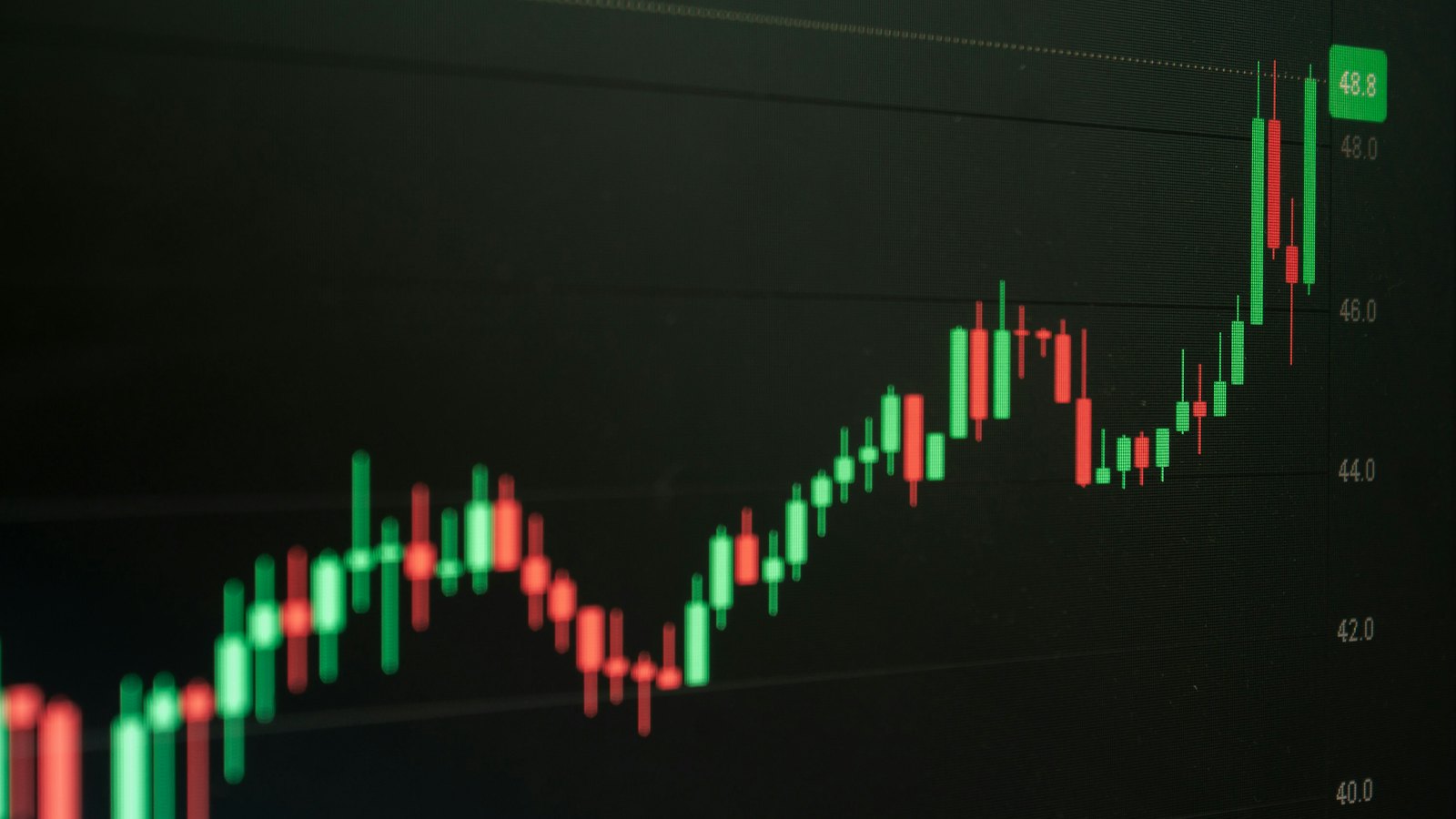 A rising candlestick chart on a dark screen