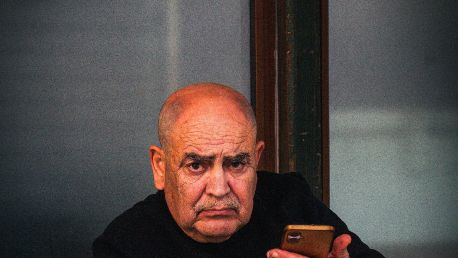 An older man holding a smartphone