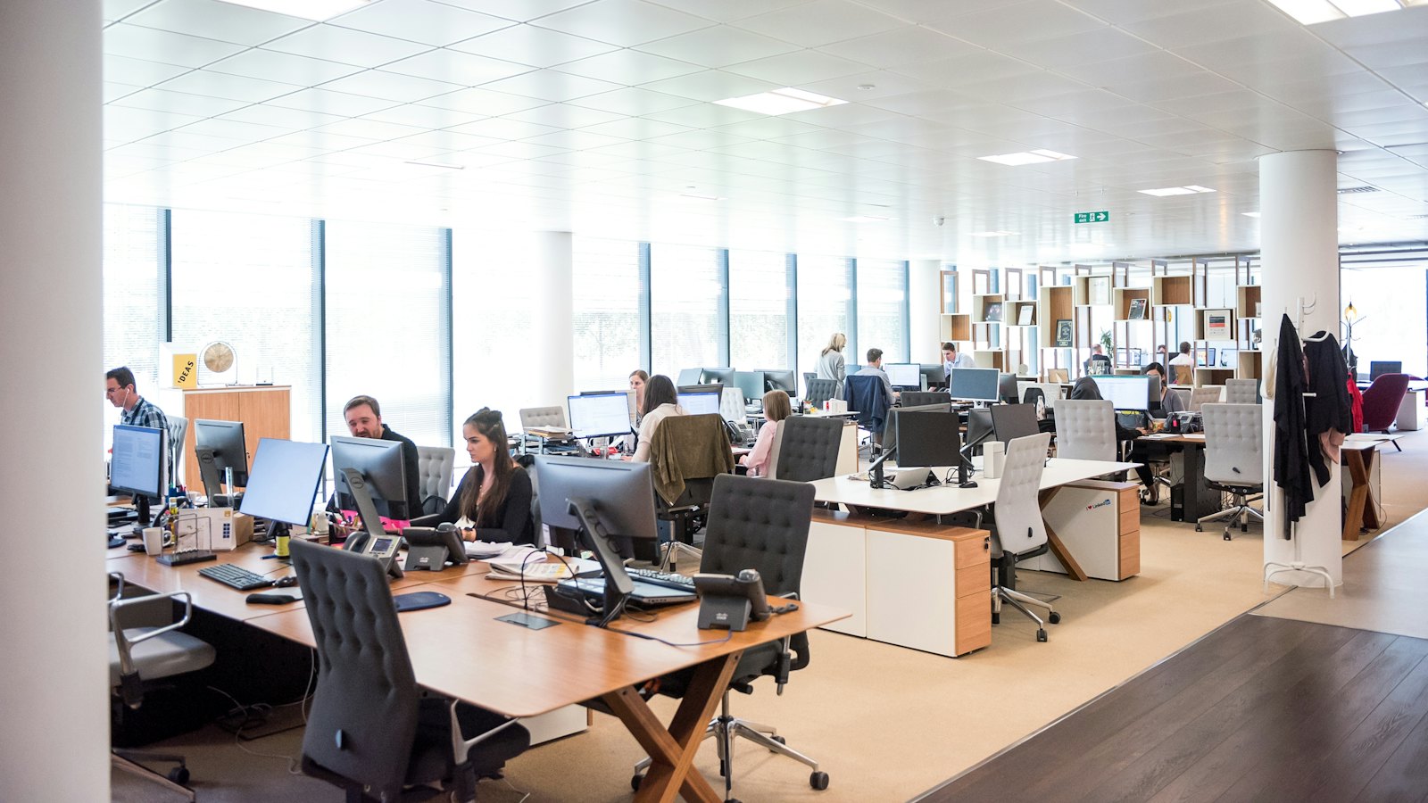 A large open-plan office with rows of desks and computers