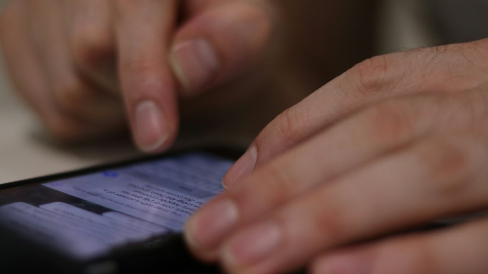 Close-up of a hand scrolling on a smartphone screen