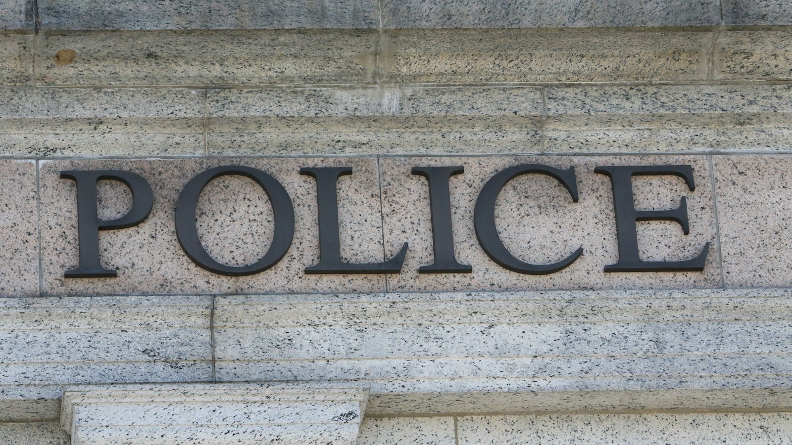 The word POLICE carved into the stone front of a building