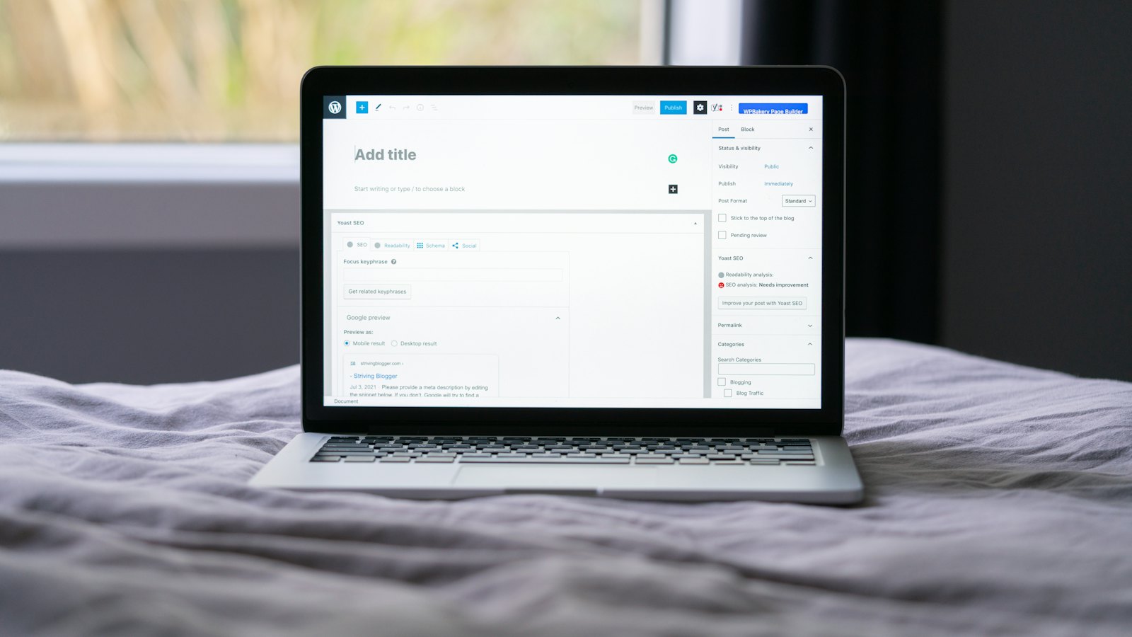 A laptop open on a bed with a web page on the screen
