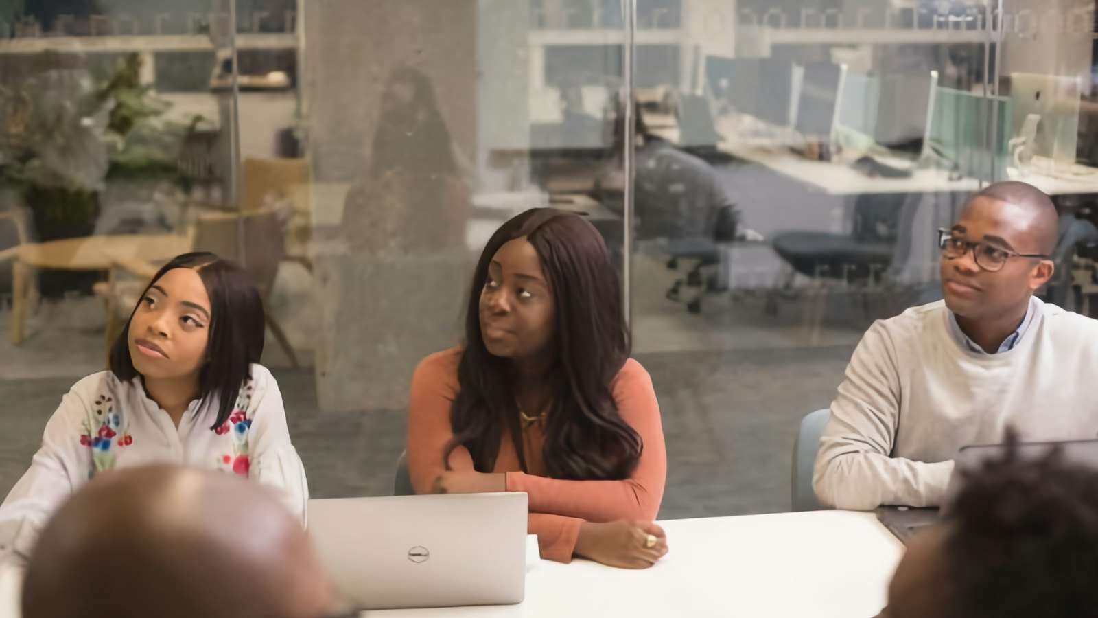 A team of colleagues around a meeting table listening to a discussion