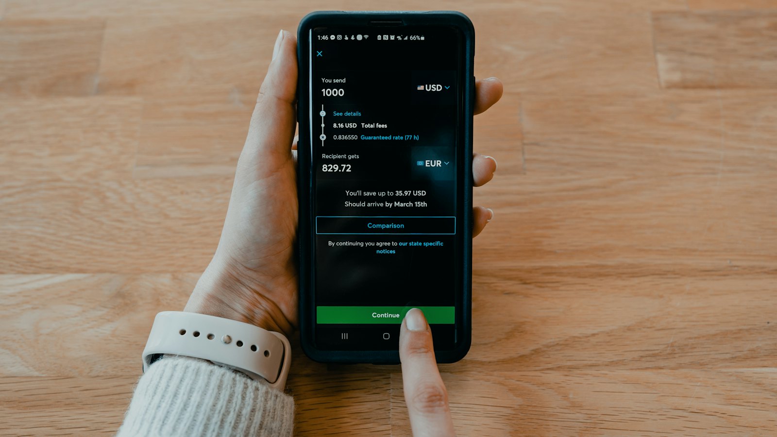 A hand holding a phone with a banking app open