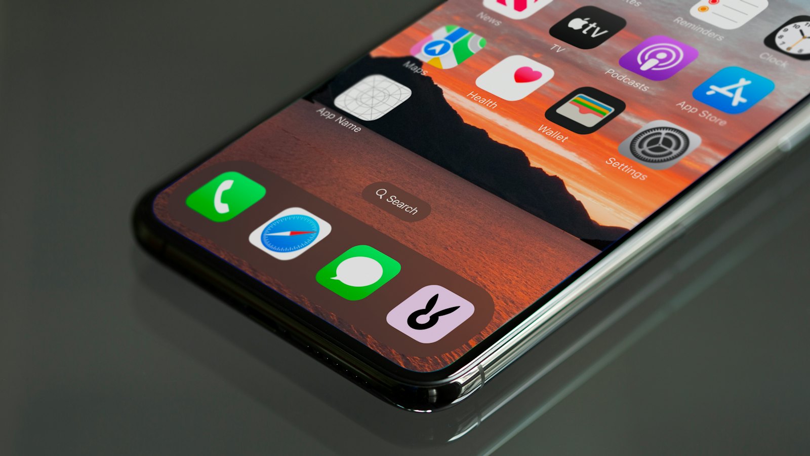 A phone lying on a dark table with app icons on screen