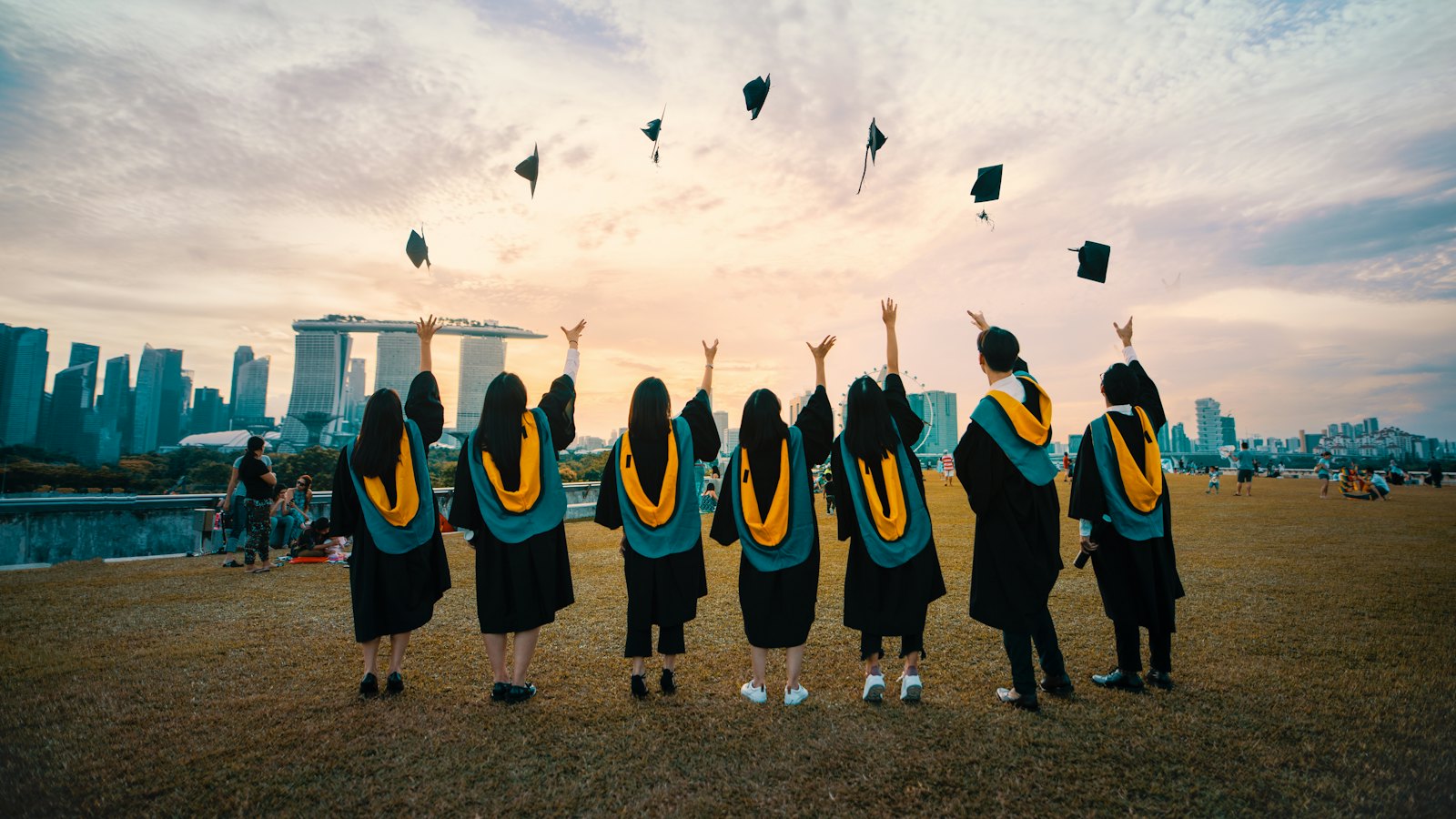 Graduates in gowns throwing their caps in the air