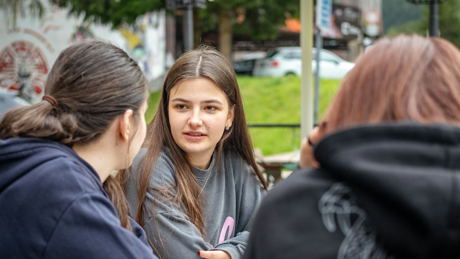 Three young people talking outdoors