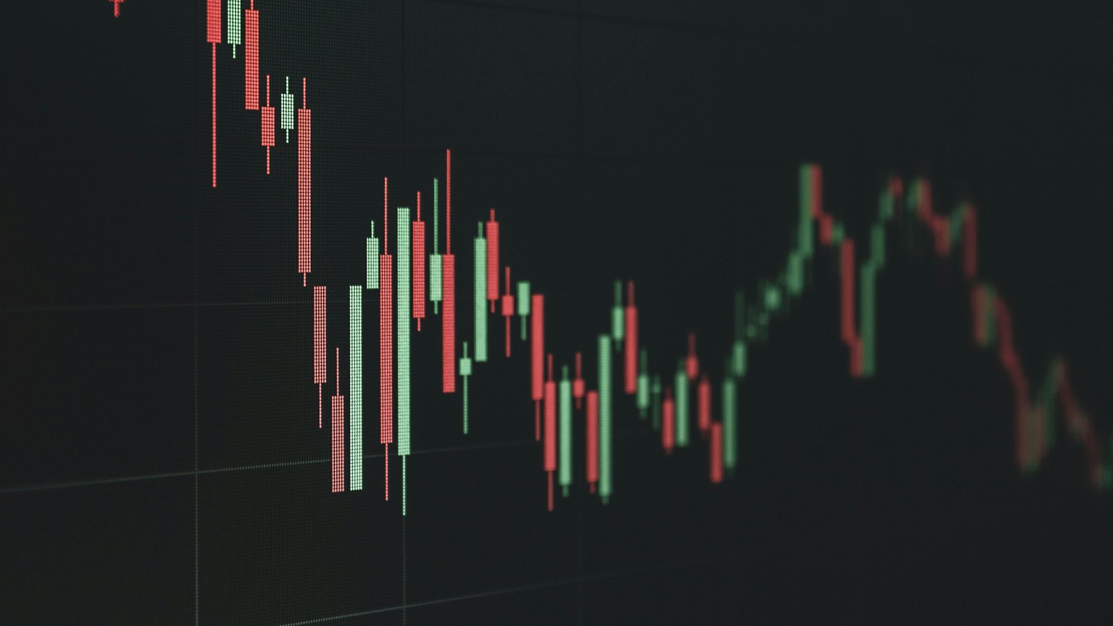 A falling candlestick chart on a dark screen