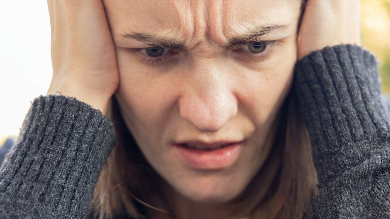 A distressed woman holding her head in her hands