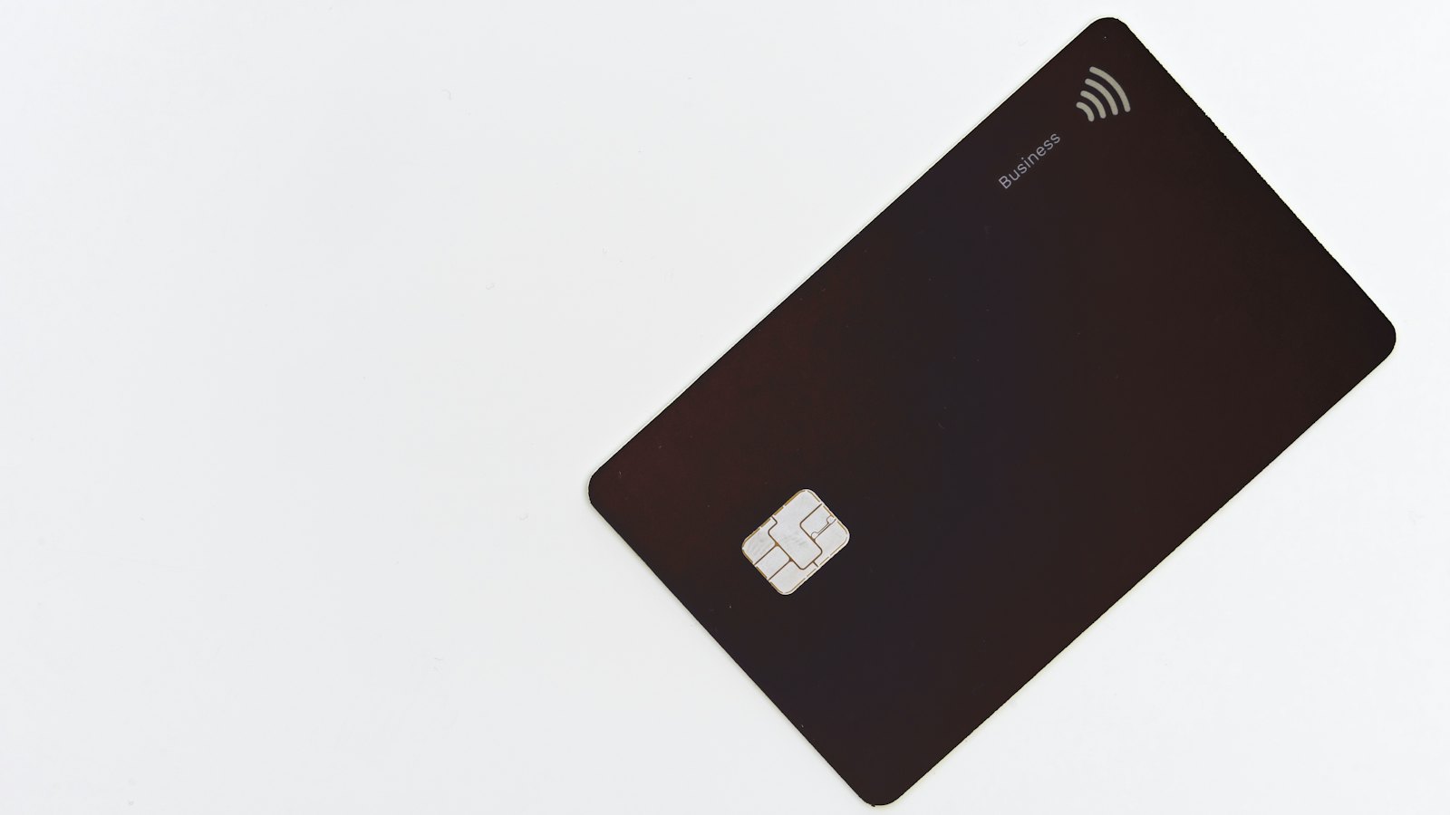 A dark payment card on a white surface