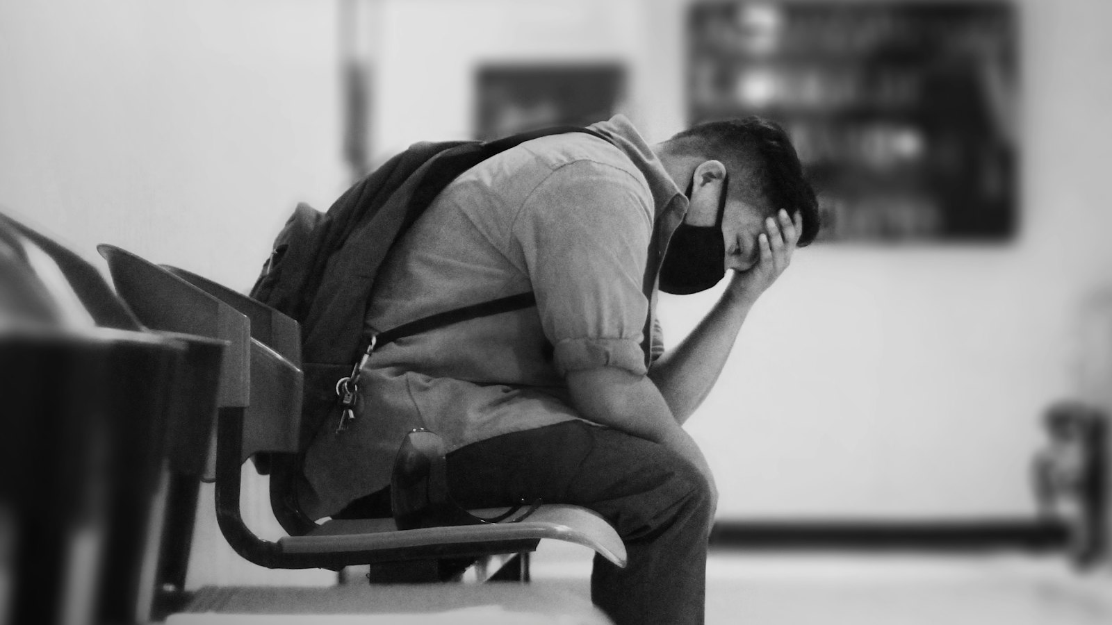 A worried man with his head in his hand at a station