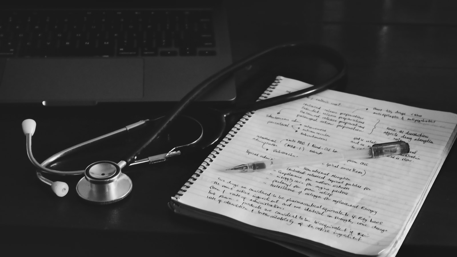 A stethoscope lying on a handwritten notebook
