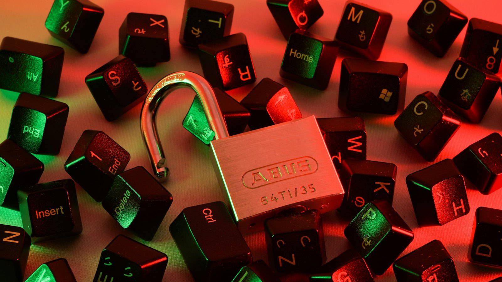 An open padlock among scattered keyboard keys