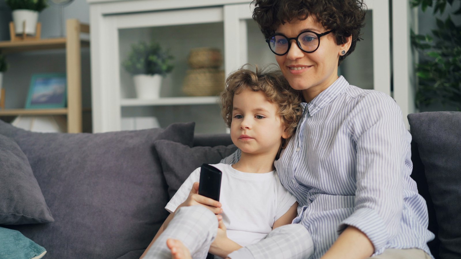 A mother holding a child on a sofa