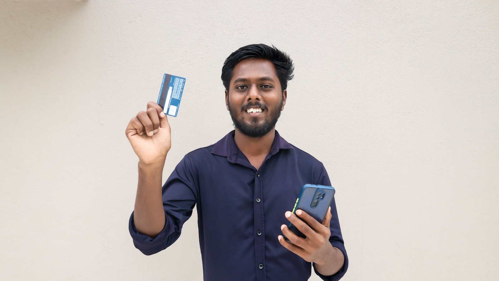 A man holding a bank card and a phone